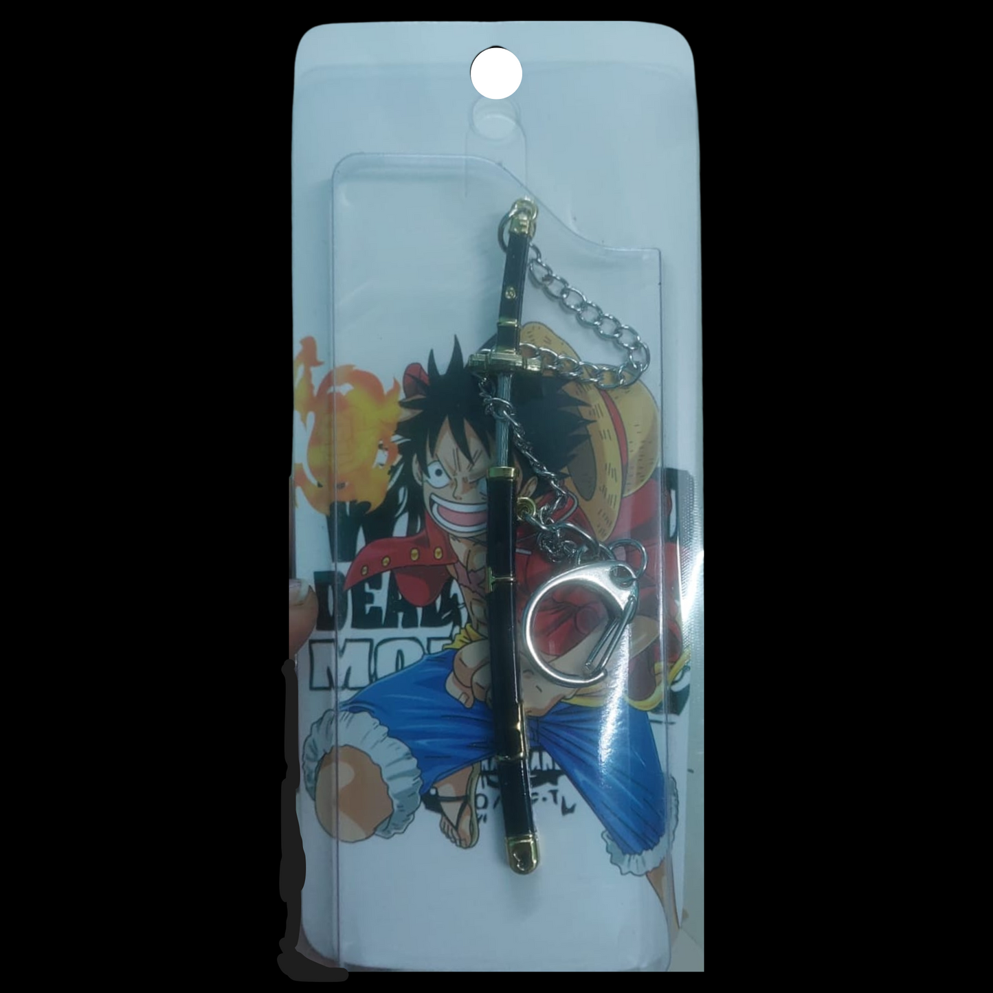 Black and gold Yubashiri katana keychain inspired by One Piece's Roronoa Zoro, placed on a dark fabric background