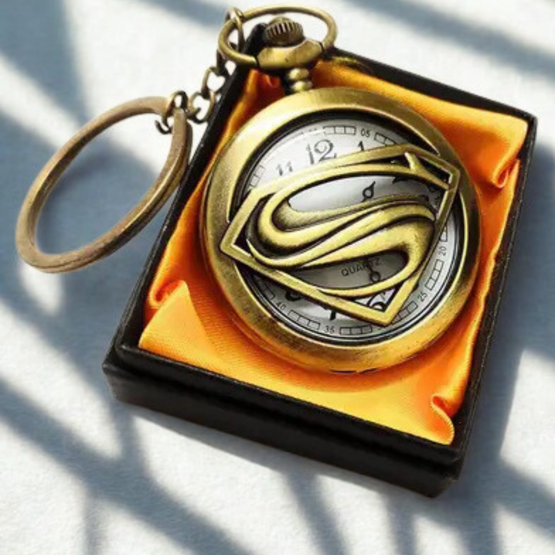 Vintage bronze Superman metal pocket watch keychain with open-view dial and iconic 'S' emblem