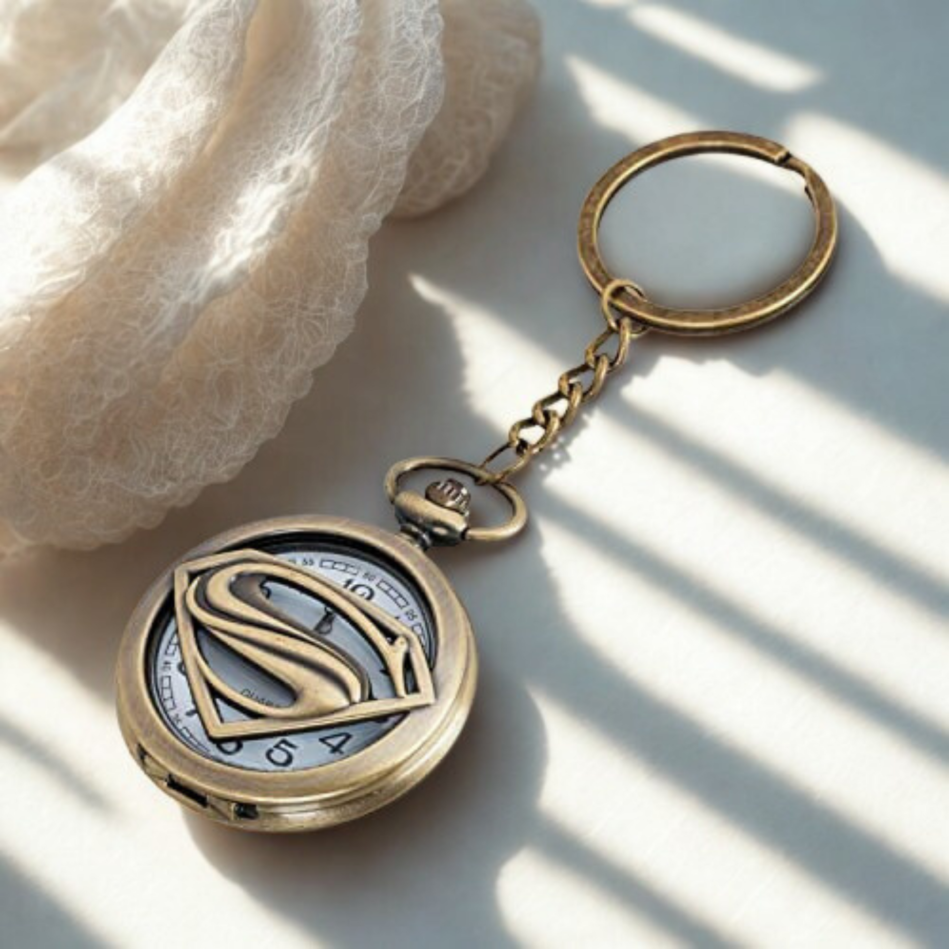 Vintage bronze Superman metal pocket watch keychain with open-view dial and iconic 'S' emblem