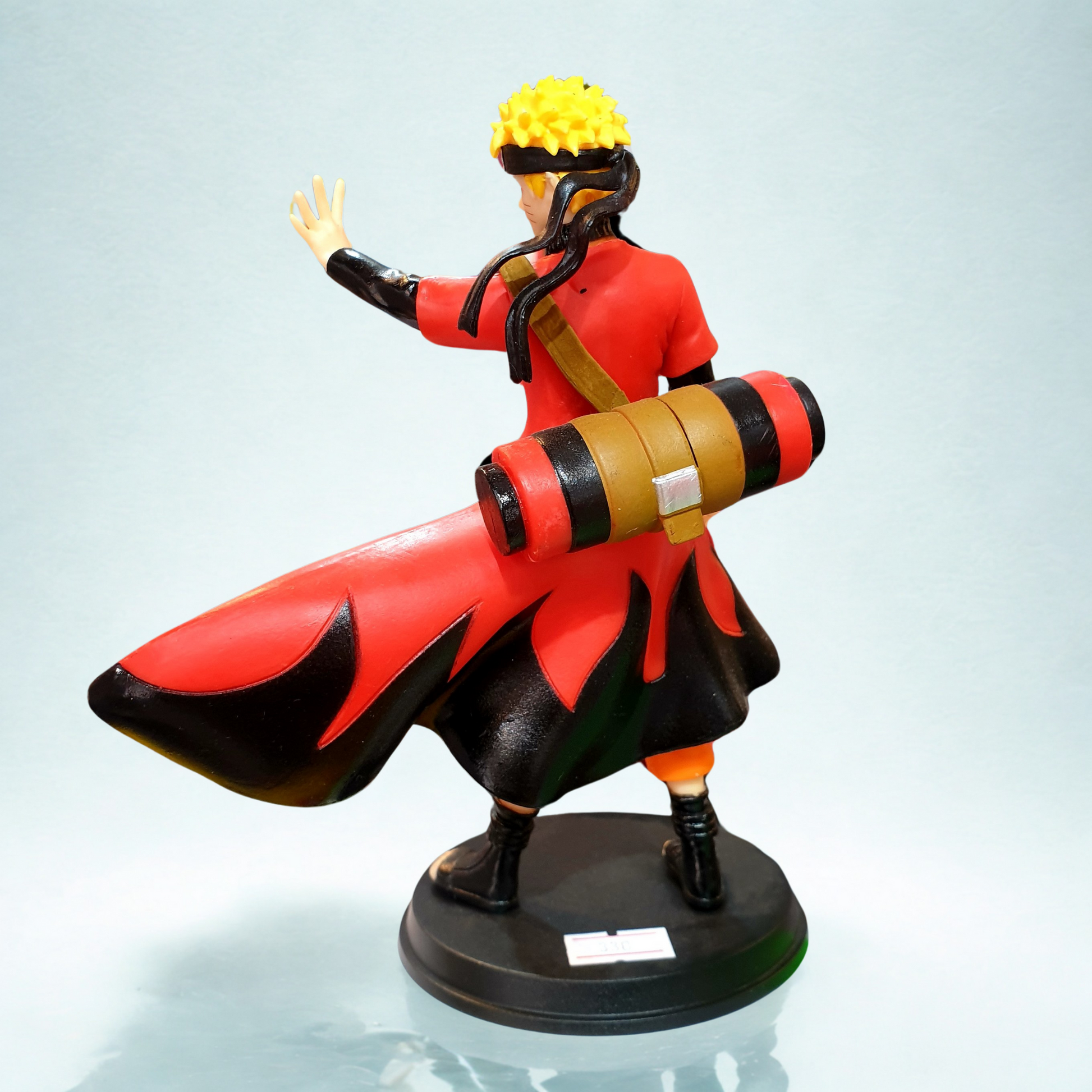 Naruto Uzumaki standing figure with red cloak, orange jumpsuit, and black ninja sandals on a round base.