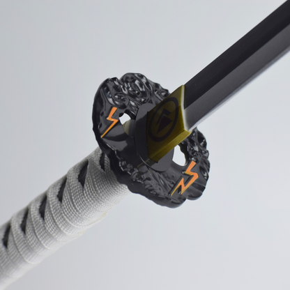 Ghost of Tsushima: Jin Sakai Wooden Katana 104cm - close-up of the black tsuba with orange lightning and the gold Sakai crest